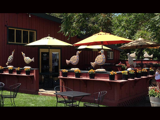 public art freestanding sculptures - seven cement and ceramic mosaic birds on railing at Pony Espresso in Jacksonville, Oregon